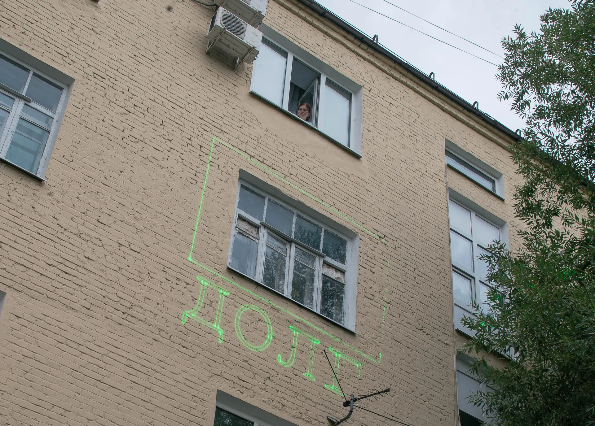 Лазерная проекция на жилом доме, которая информирует жильцов о долгах за коммунальные платежи