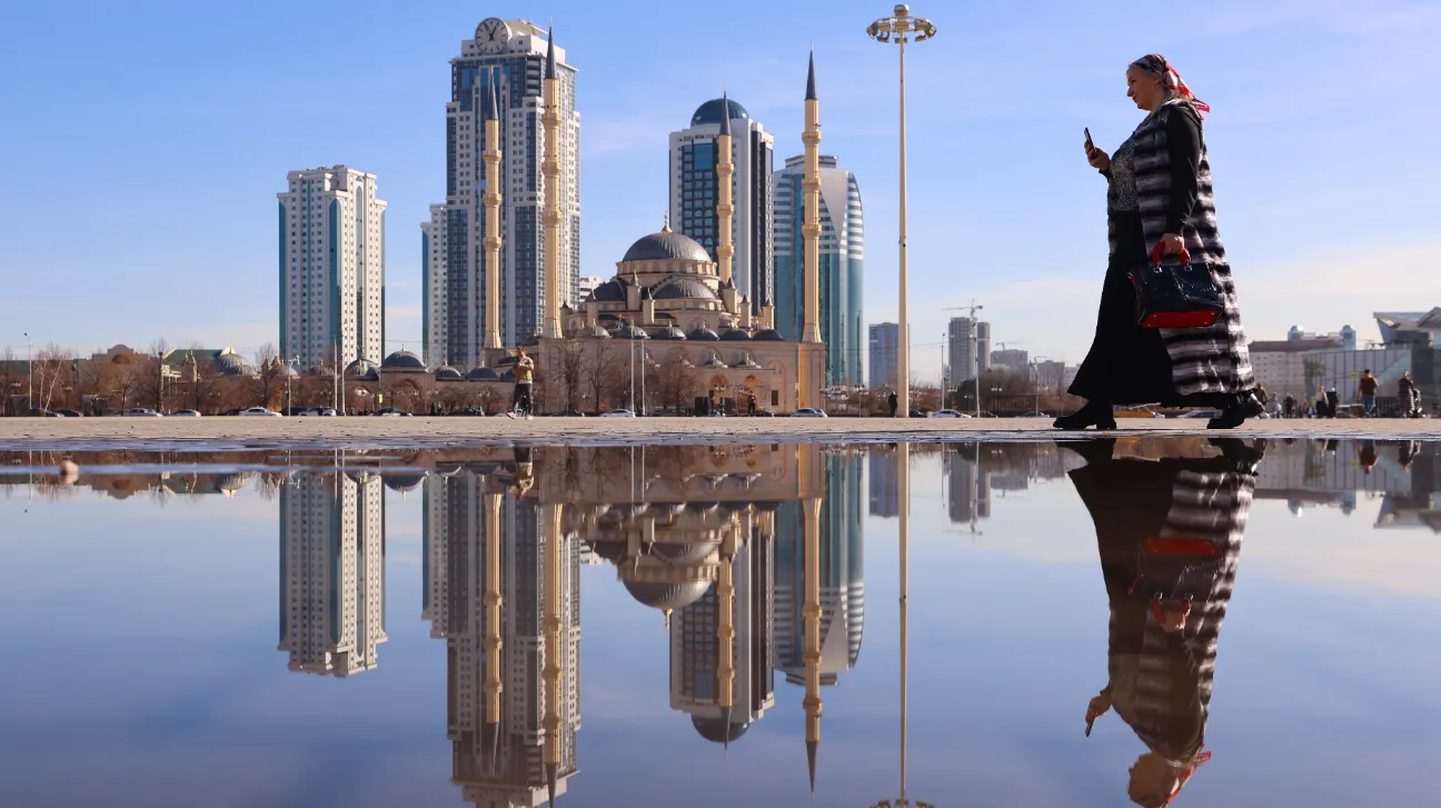 Россия. Чеченская Республика. Грозный. Женщина во время прогулки на площади у мечети «Сердце Чечни».