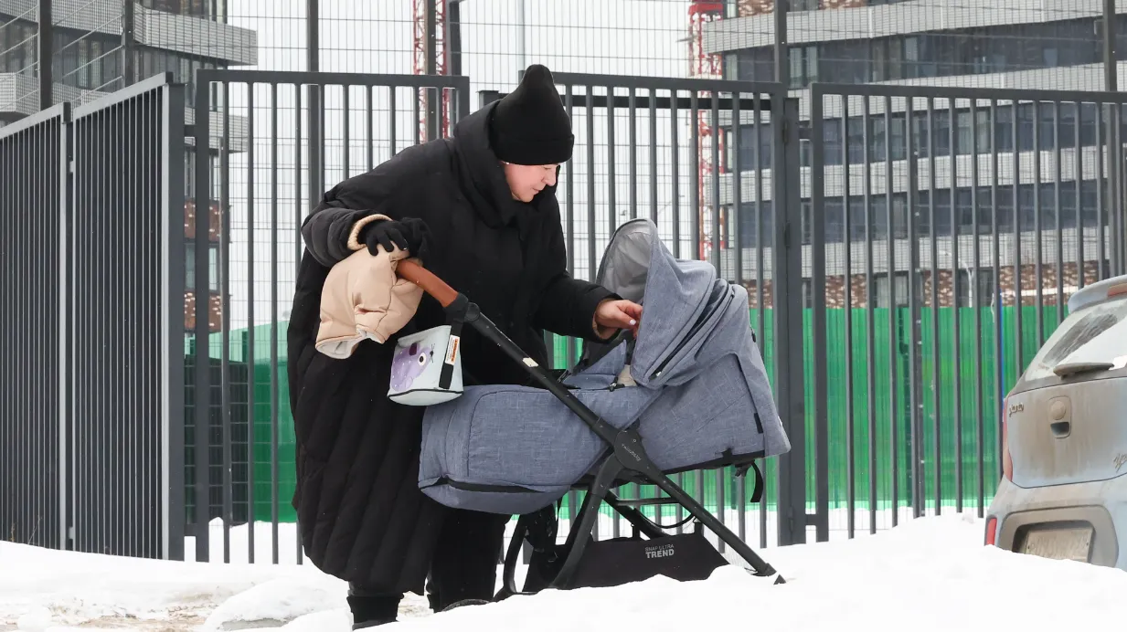 Россия. Москва. Женщина с ребенком у строящихся домов