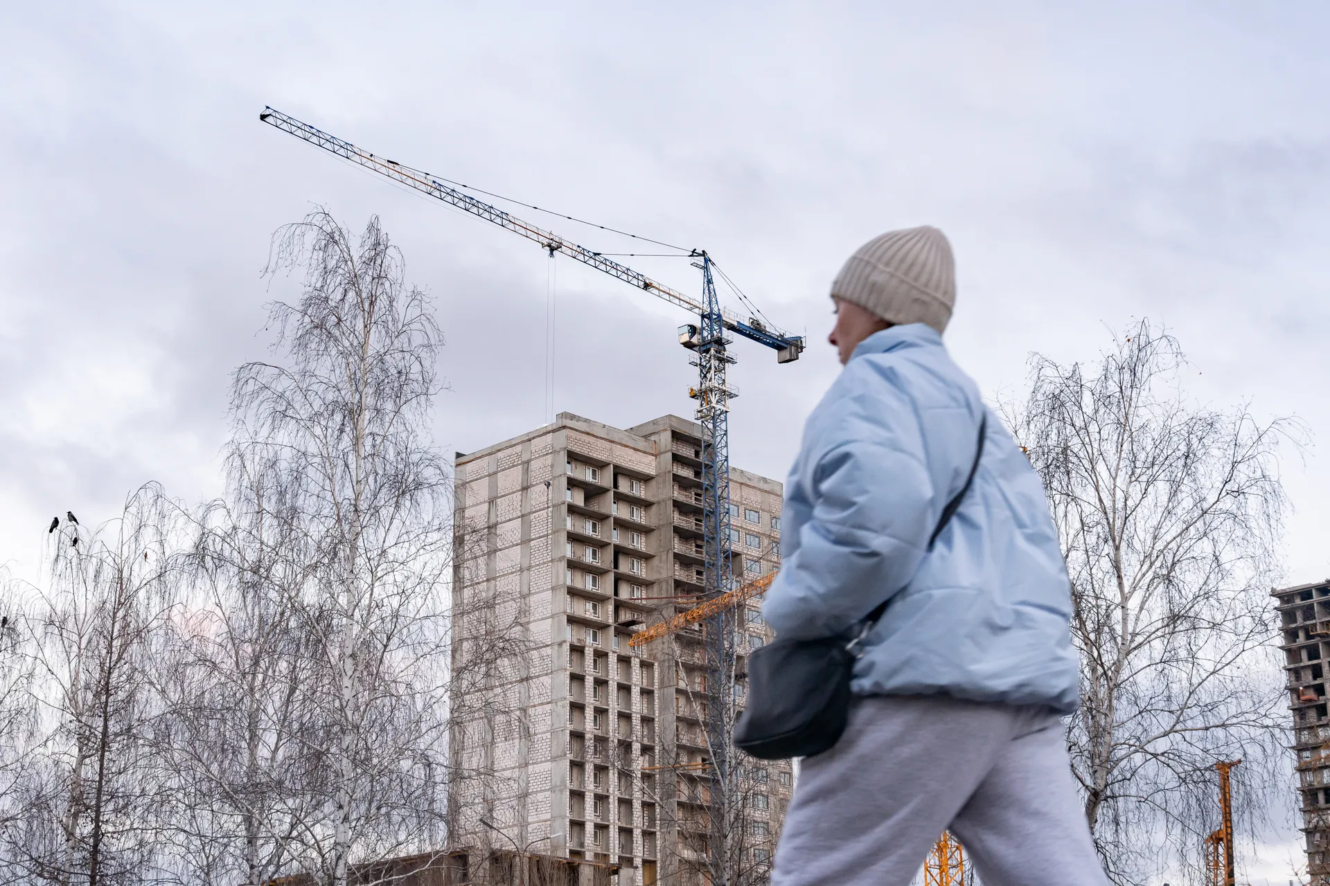 Татарстан. Набережные Челны. Женщина у строящегося жилого комплекса на проспекте Сююмибике