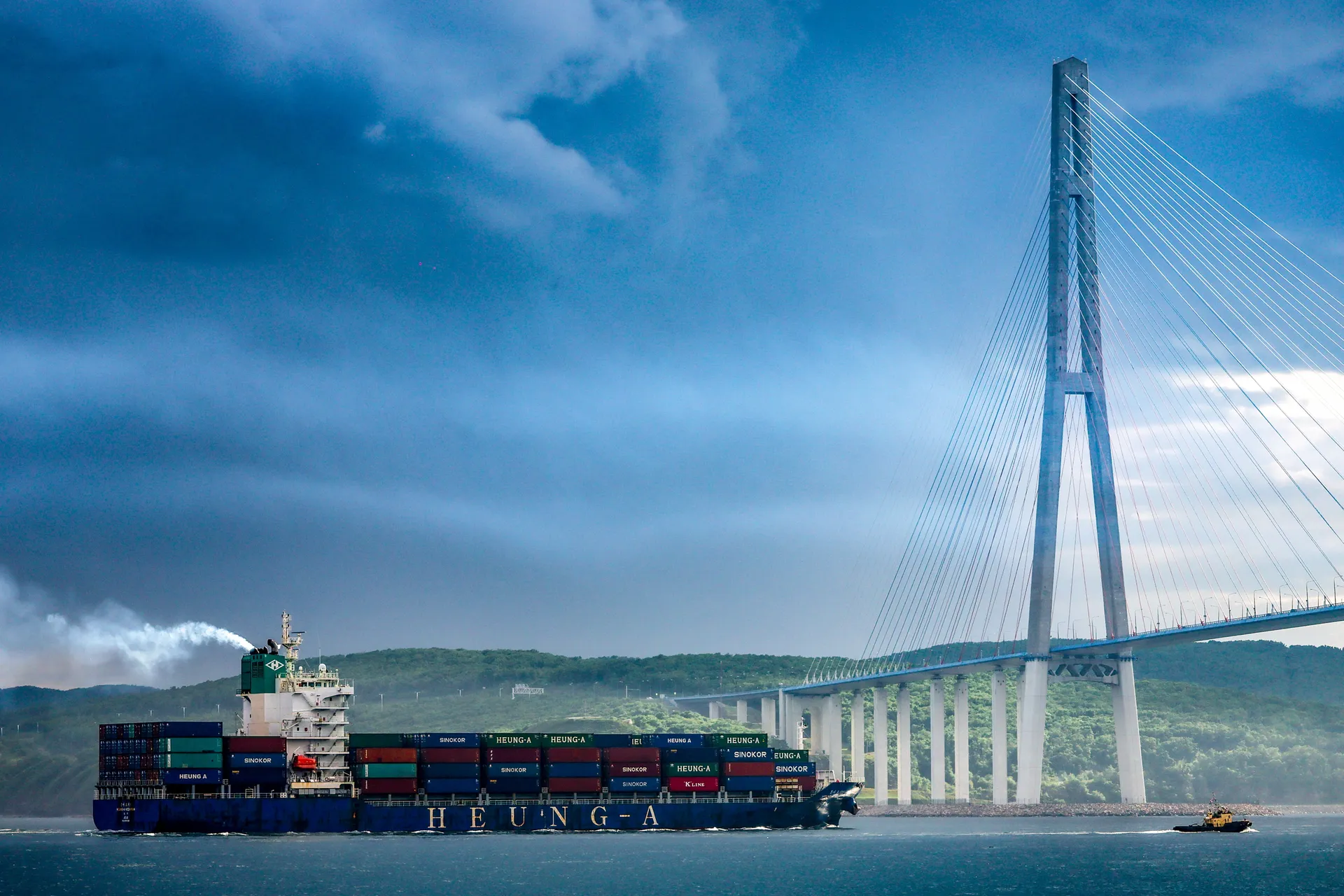 Приморский край. Владивосток. Контейнеровоз на входе в пролив Босфор Восточный у вантового моста на остров Русский.