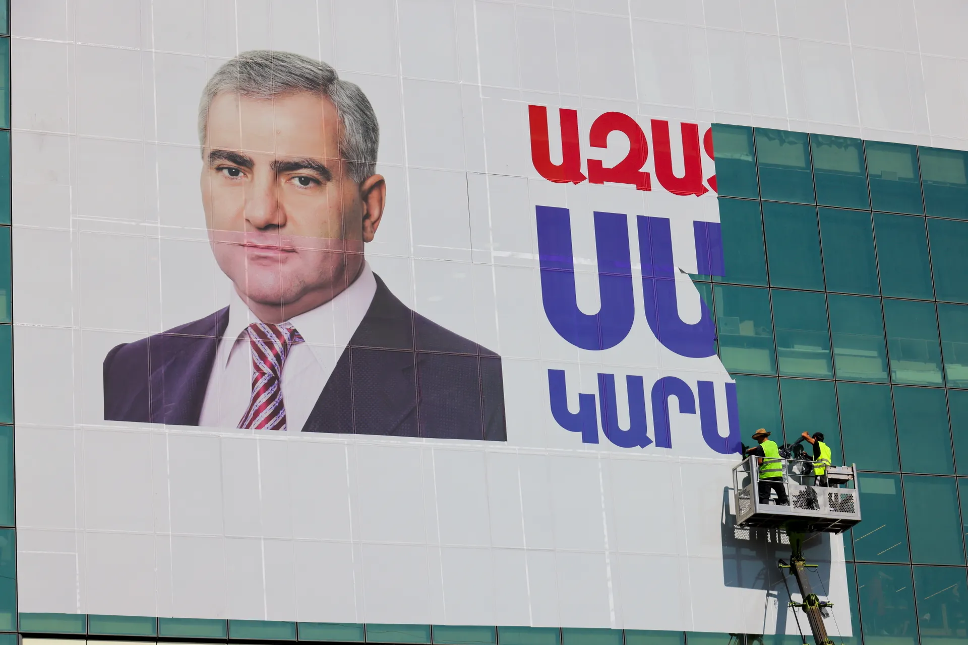 Армения. Ереван. Рабочие на подъемнике демонтируют баннер с надписью «Свободу Самвелу Карапетяну» с принадлежащего ему торгового центра «Ташир».